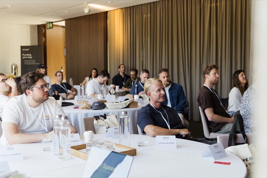 Founders seated at tables during a session